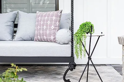 Sophia swing bed in black with a gray cushion bundle, mauve print pillow, and black rope hanging kit
