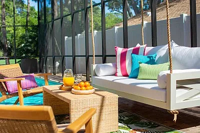 White Maggie Daybed Swing with Teak Furniture and Blue Sunbrella Curtains