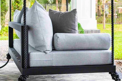 Close-up of the Sophia swing bed black frame with black rope hanging kit and gray cushions