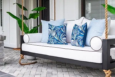Maggie swing bed in black with white piped cushions and blue palm print pillows