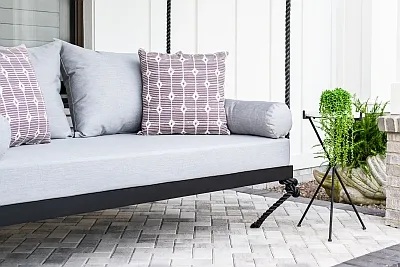Sophia swing bed in black with gray cushions and mauve print pillows