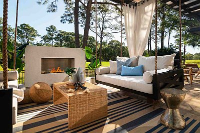 Black Maggie Daybed Swing with White Sunbrella Curtains and Blue and Tan Safavieh Outdoor Rug 
